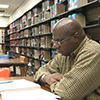 man in library studying a book