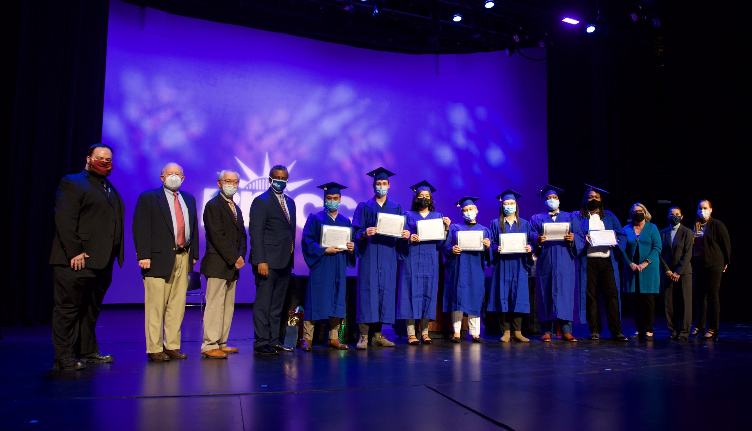Professors, students and staff on stage at paramedic graduation