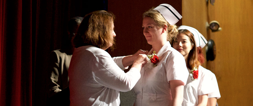 nurse receiving pin in nursing pinning ceremony