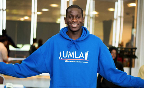 male student wearing UMLA sweatshirt smling