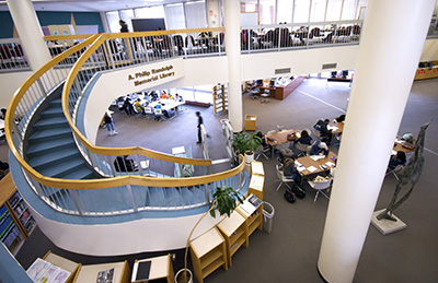 Looking at the library from the 5th floor balcony with its spiral staircase and students studying at tables